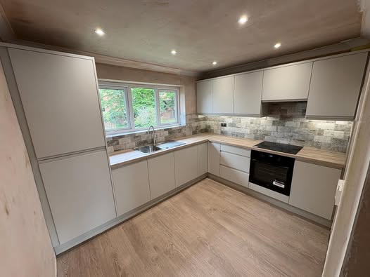 May be an image of kitchen island, cooker hood, indoors and sliding door
