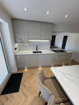 May be an image of kitchen island, sink, cooker hood, lighting and indoors