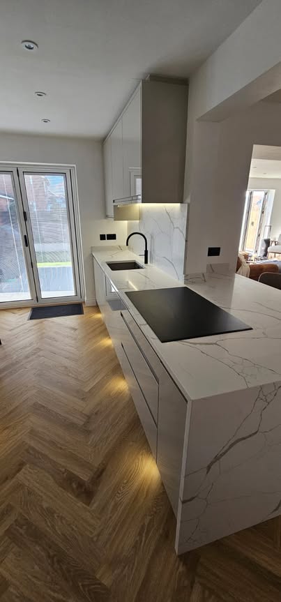 May be an image of cooker hood, lighting, kitchen island and indoors